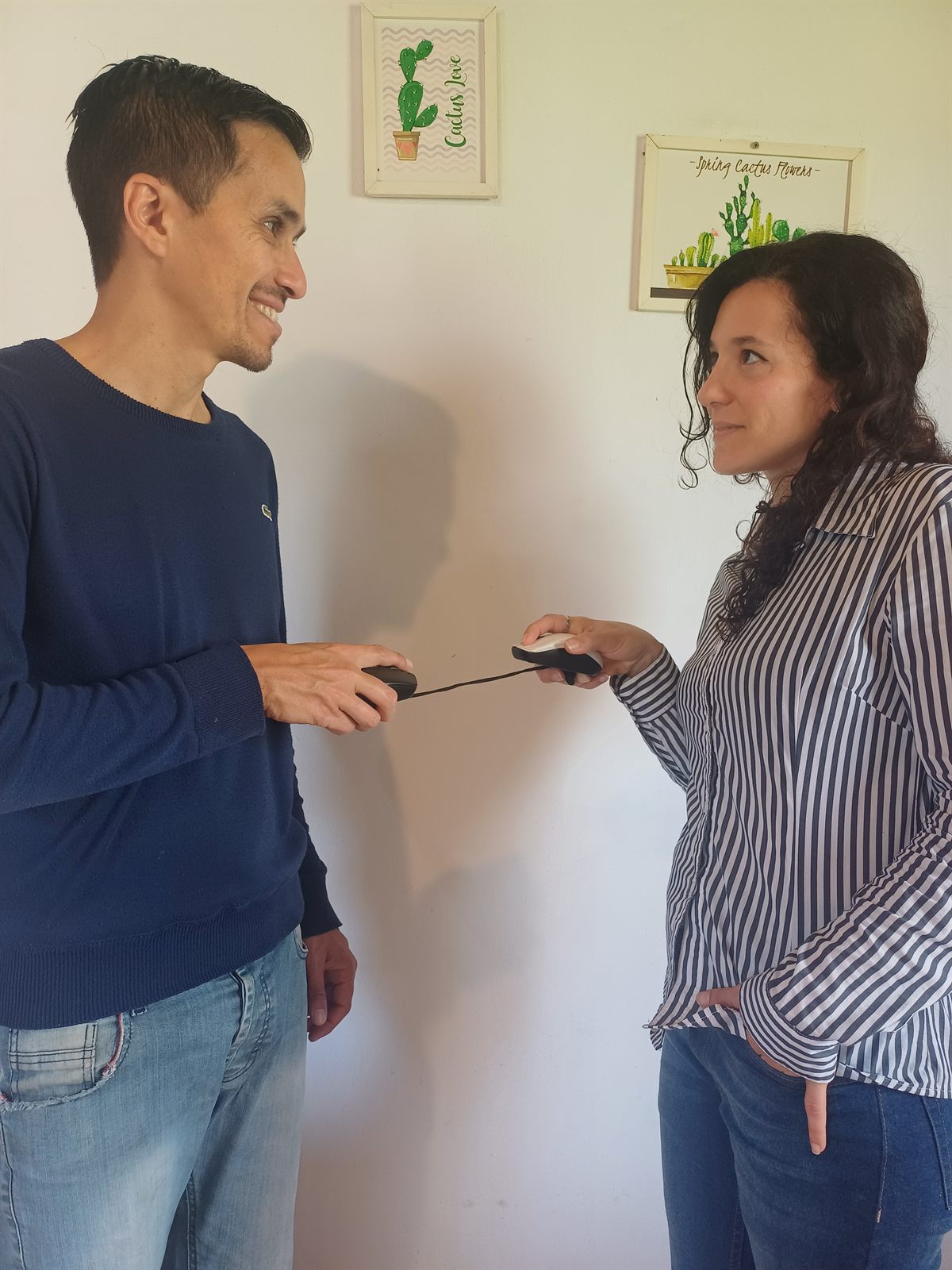 Samuel y Eliana, cada uno con un mouse en la mano, conectados por el cable